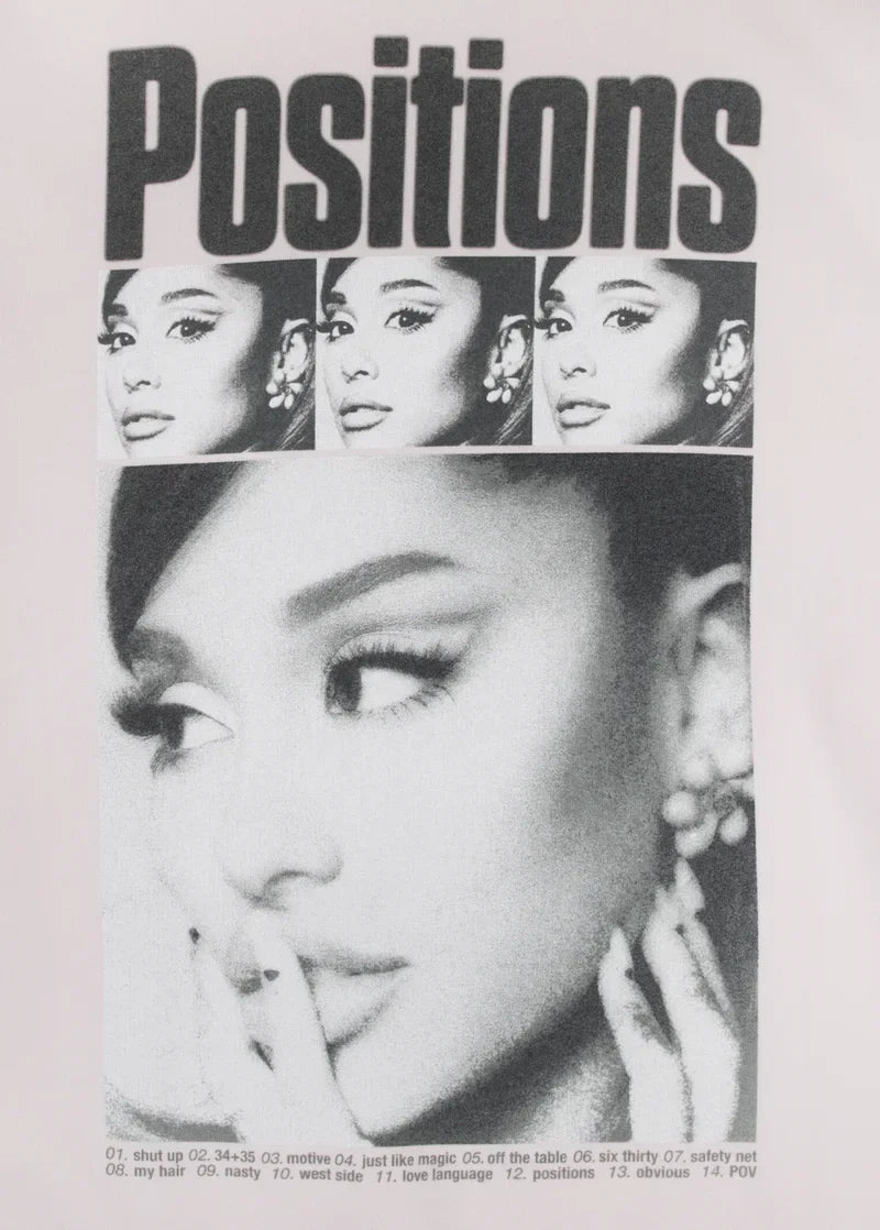 Closeup detail of Ariana Grande Positions rewind graphic on pink crewneck with monochrome portrait artwork