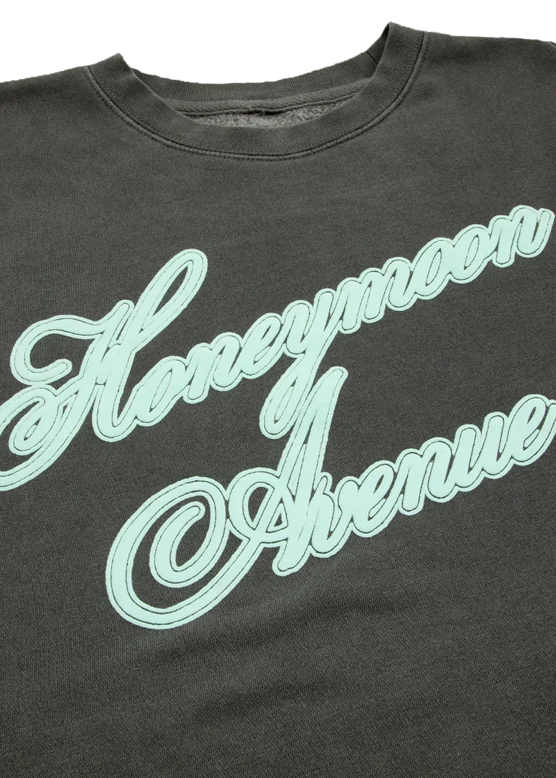Closeup detail of Ariana Grande Honeymoon Avenue script graphic on vintage charcoal crewneck