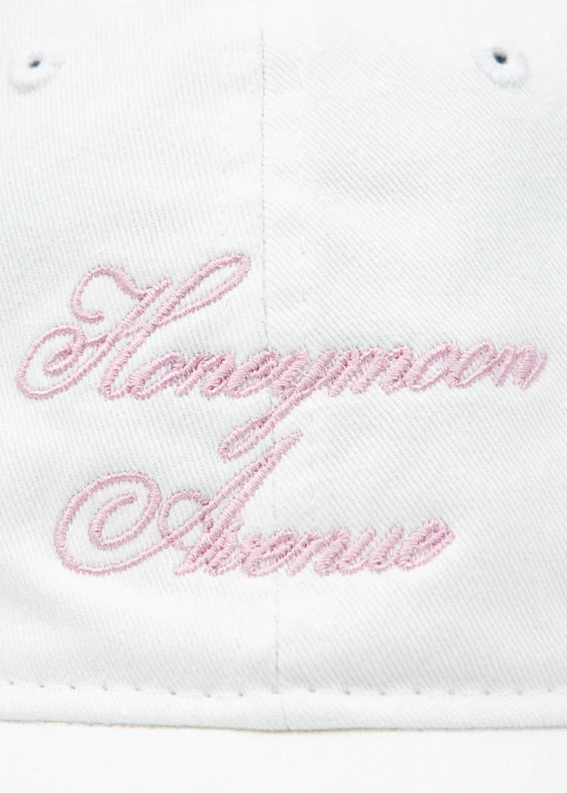 Close-up of pink Honeymoon Avenue embroidery on white Ariana Grande Yours Truly anniversary dad hat
