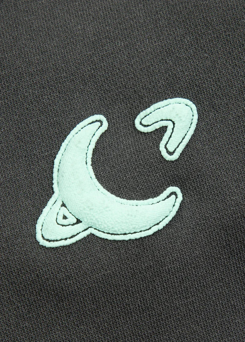 Closeup detail of Ariana Grande Yours Truly sweatpants with mint embroidered moon logo on charcoal fabric