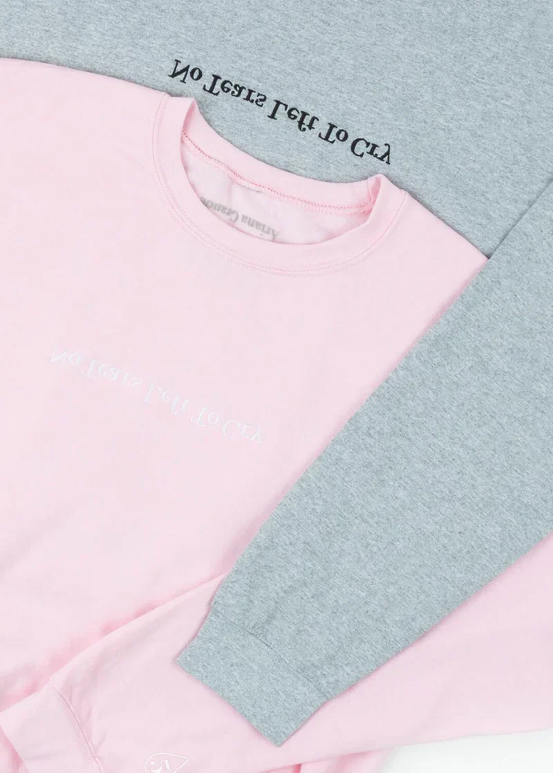 Ariana Grande no tears left to cry anniversary crewneck in pink and grey folded lifestyle product display