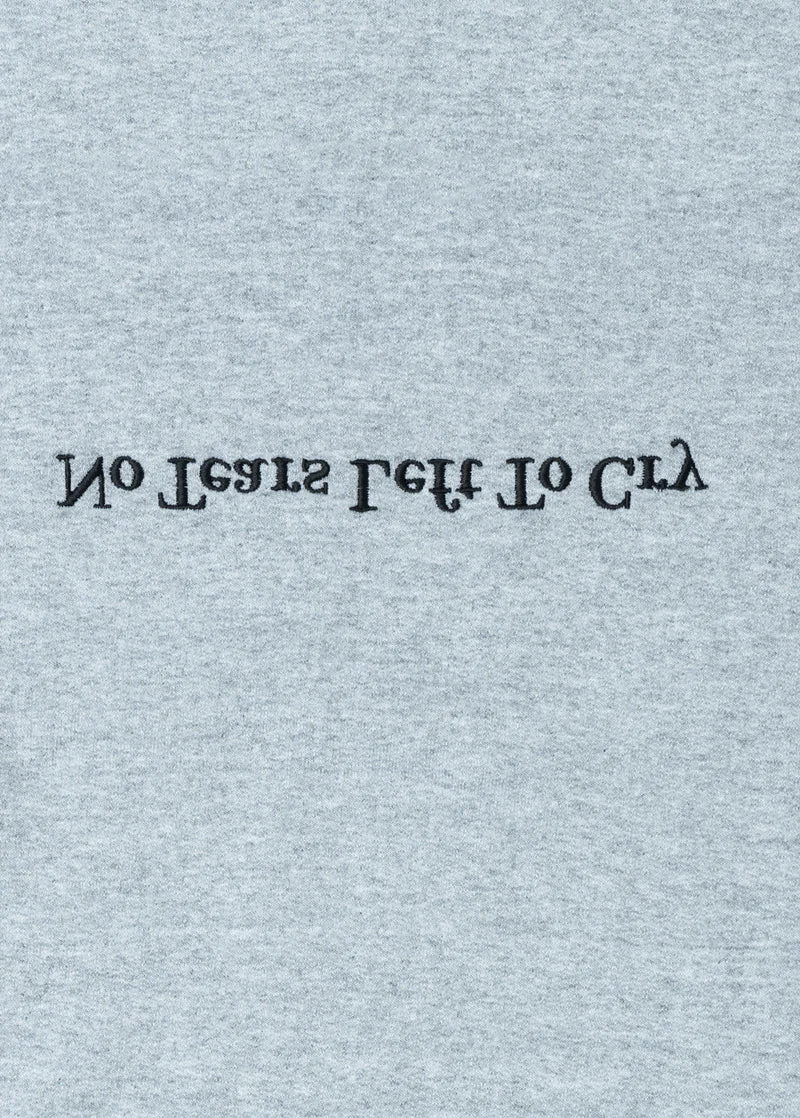 Close-up detail of Ariana Grande No Tears Left to Cry grey crewneck featuring inverted embroidered typography graphic