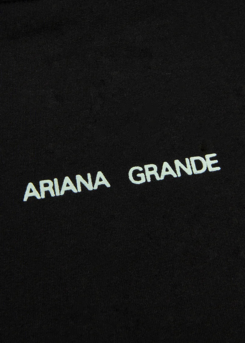 Closeup detail of Ariana Grande logo print on black Positions hoodie with minimalist aesthetic