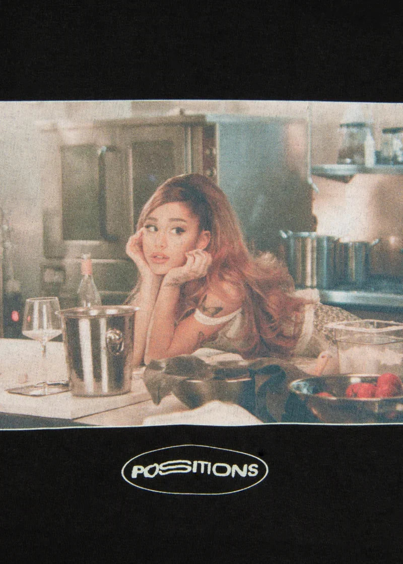 Closeup detail of Ariana Grande Positions photo graphic on black hoodie with cinematic album-inspired artwork