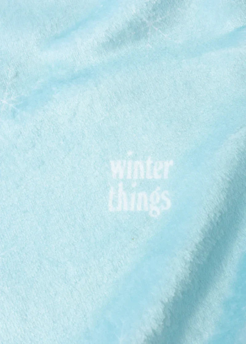 Close-up detail of Ariana Grande Winter Things blue fleece fabric with subtle winter holiday text graphic
